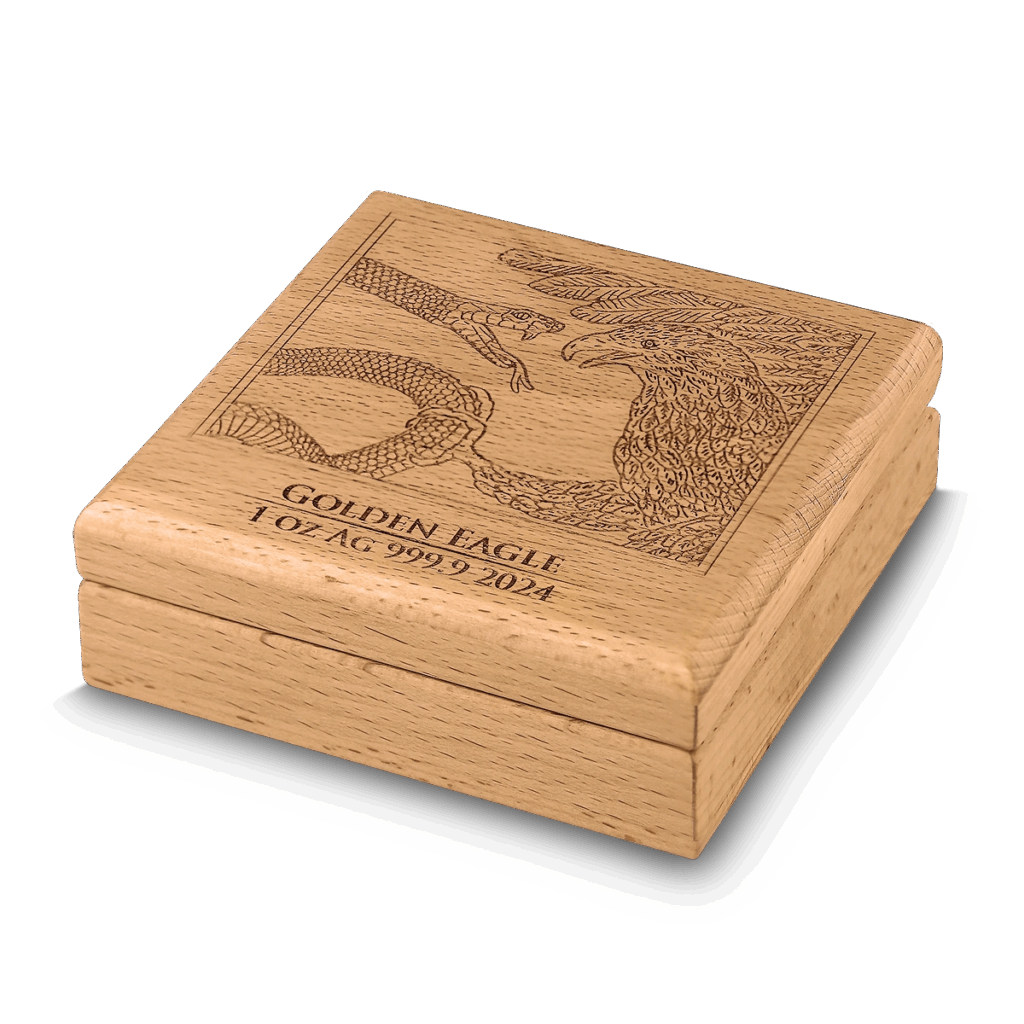 Un cofanetto in legno chiaro presenta un'incisione dettagliata di un'aquila e di un serpente sul coperchio, con la dicitura GOLDEN EAGLE 1 OZ AG 999.9 2024, per il Prime Bullion - 2024 Malta Golden Eagle 5 Euro 1 oz Argento BU Edizione Limitata.