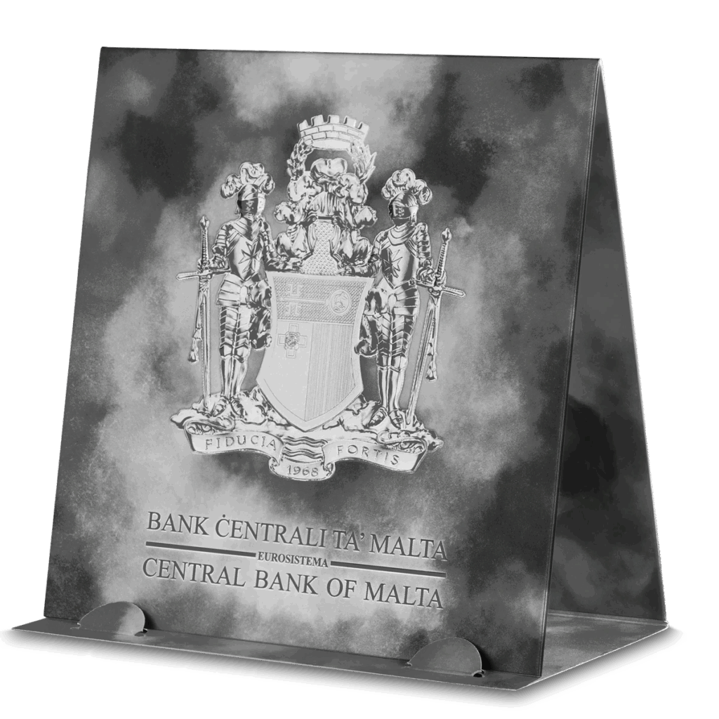 Espositore triangolare per la moneta 2023 Cavalieri del Passato 5 Euro 1 oz Argento Fior di Conio, con lo stemma di Malta e la scritta "Bank Ċentrali Ta' Malta Eurosystem Central Bank of Malta" su sfondo grigio nuvoloso.