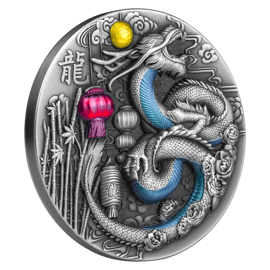 The Year of the Dragon 2024 CFA Francs silver coin showcases a detailed dragon in relief with blue accents, bamboo, clouds, flowers, a yellow sun, and red lanterns, plus Chinese characters and intricate patterns in the background.
